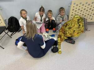 Pielęgniarka siedząca przed grupa dzieci