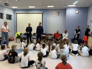 Policjanci stojący a przed nimi grupa dzieci