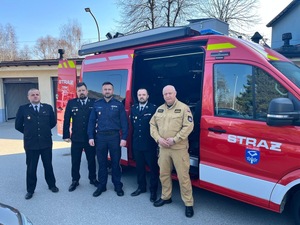 Komendanci pozujący do zdjęcia z pojazdem osp