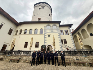 policjanci pozujący do zdjęcia przed zamkiem w Żylinie