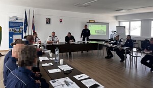sala i siedzący za biurkami policjanci w trakcie szkolenia
