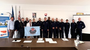 policjanci pozujący do zdjęcia z flagą a na niej logo suskiej komendy