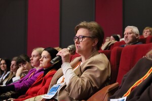 słuchaczka z mikrofonem zadająca pytanie eksertowi