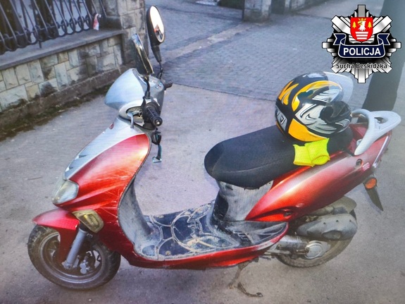 Zaparkowany motorower marki Kymco koloru czerwonego