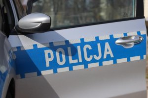 drzwi od policyjnego radiowozu z napisem Policja