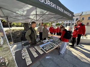 grupa osób przy stoisku Babiogorskiego parku narodowego