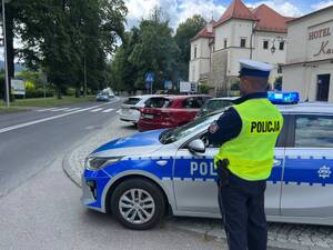 policjant stojący przy radiowozie