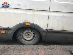 przytłoczone ciężarem desek tylne koło pojazdu