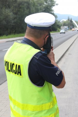 policjant mierzący miernikiem w jadące samochody