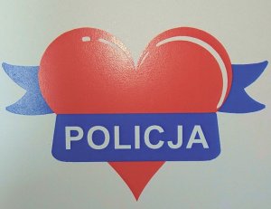 Zdjęcie przedstawiające czerwone serce oraz niebieski napis Policja.