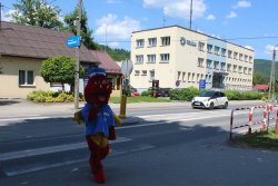 idący na pasach bezpieczeństwa policek na tle suskiej komendy