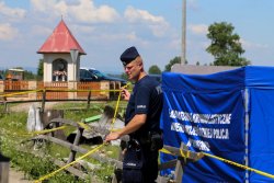 policjanci prowadzący czynności na miejscu zdarzenia i ogradzają taśmami miejsce