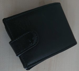 czarny męski portfel położony na jasnym stoliku