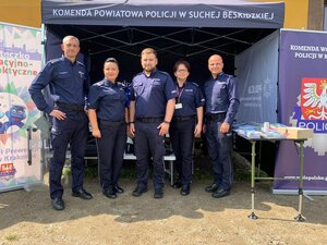 policjantki i policjanci pozujący do zdjęcia przed  stoiskiem policji