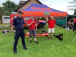 pod namiotem gopru jeden z ratowników przemawia przez mikrofon w obecności policjanta