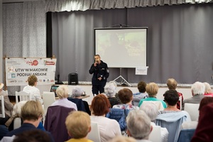 policjant prowadzący prelekcje na temat zagrożeń seniorów