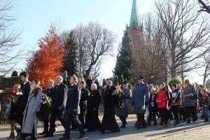 przemarsz osób w tym Komendant wraz policjantem niosącym kwiaty