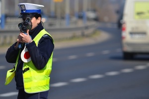 policjantka ze skierowanym miernikiem laserowym w stronę kierujących