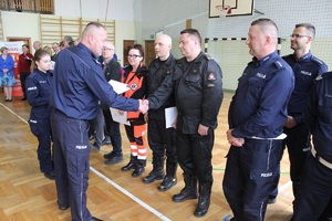 Komendant powiatowy Policji wręcza podziękowania gościom w tym zastępcy komendanta powiatowego straży pożarnej