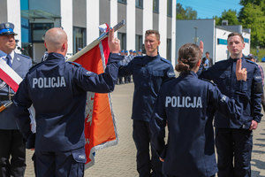 ślubujący obok sztandaru policjanci i policjantka