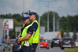 dwóch policjantów ruchu drogowego spoglądających przy drodze na ruch pojazdów