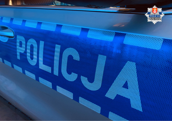 napis Policja na drzwiach samochodu podświetlony na niebiesko