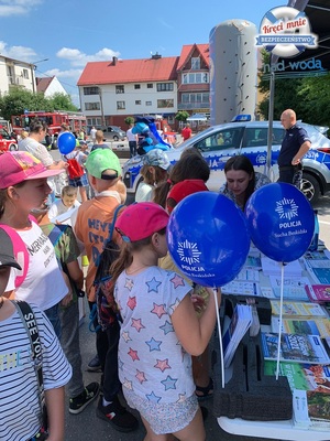 dzieci stojące przy namiocie policjantów a obok niebieskie balony z logo kpp sucha beskidzka