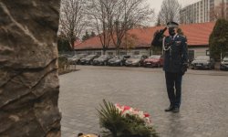 Komendant Wojewódzki Policji salutuje przed pomnikiem poległych policjantów znajdujący się na terenie Komendy Wojewódzkiej Policji w Krakowie.