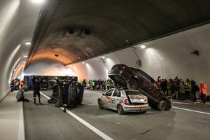 rozbite samochodu na środku jezdnia oraz obserwatorzy stojący obok podczas ćwiczeń w tunelu
