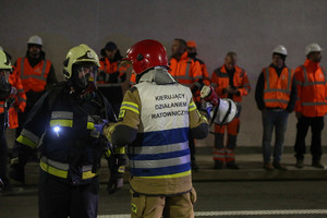 naradzający się dowódca kierujący działaniami ratowniczymi ze strażakiem podczas ćwiczeń w tunelu