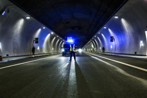 policjant a za nim oświetlony radiowóz na środku jezdni podczas ćwiczeń w tunelu