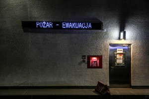 ściana na której jest wyświetlana informacja pożar ewakuacja podczas ćwiczeń w tunelu