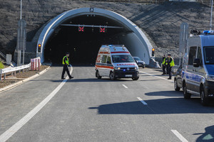 wjazd do tunelu z stojąca na ulicy karetką i policjantami podczas ćwiczeń w tunelu