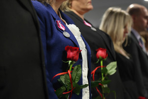 róże trzymane przez służbę cywilną i medale zawieszone marynarkach