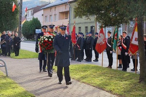 maszerujący w stronę pomnika komendanci z wieńcem