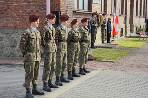 stojący w szeregu obok pomnika strzelcy w mundurach wojskowych