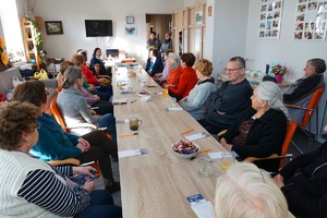 siedzący przy stole seniorzy wysłuchują rozmowy pracownicy ZUS