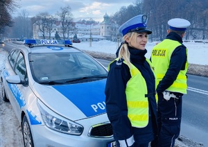 policjanci a w tle zamek suski w zimowej scenerii