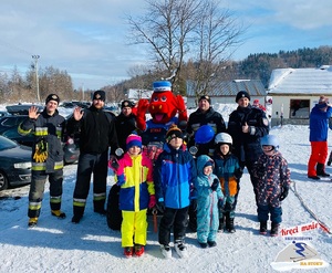 dzieci strażacy policjant i goprowcy na quadzie z polickiem pozują do zdjęcia obok stoku narciarskiego