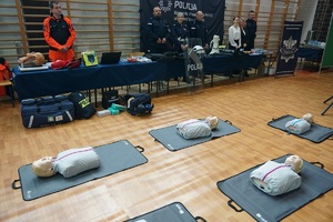stoisko Policji i manekiny ułożone na ziemi do ćwiczenia pierwszej pomocy
