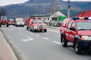 jadące w kolumnie samochody straży pożarnej na drodze krajowej