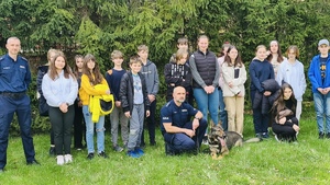 pamiątkowe zdjęcie dzieci z psem hassanem i policjantami