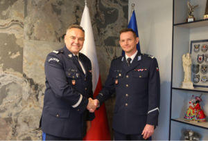 Komendant Wojewódzki Policji ściska rękę nowemu pełniącemu obowiązki komendanta Powiatowego w Suchej Beskidzkiej