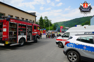 zaparkowane pojazdy policji straży i karetka straży pożarnej na placu komendy