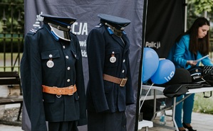 mundury policji granatowej a obok stoisko informacyjne
