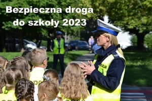 zdjęcie przedstawiające policjantkę ruchu drogowego w obecności stojącej przy niej dzieci