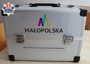 zdjęcie srebrnej walizki profilaktycznej na której widnieje logo małopolski z informacją jej sfinansowania