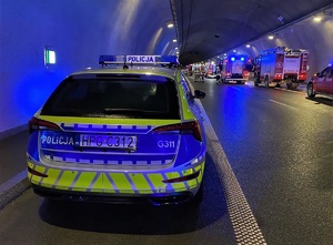 policyjny radiowóz w tunelu podczas ćwiczeń, w tle auta strażackie