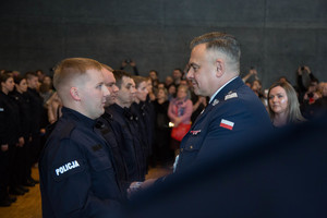 Pan Komendant Wojewódzki Policji wręcza nowemu policjantowi legitymacje policyjną