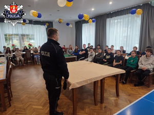 policjant stojący przed gupa dzieci i młodzieży w zawoi